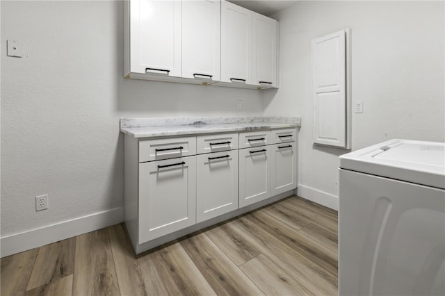 washroom with cabinets, light wood-type flooring, and washer / clothes dryer