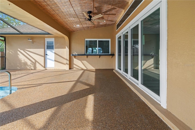 view of patio featuring ceiling fan and glass enclosure