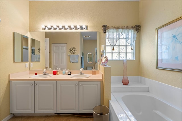 bathroom featuring tile patterned floors, tiled tub, and vanity