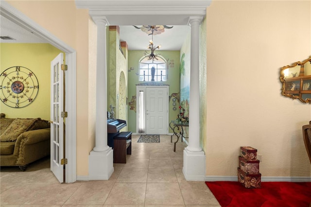 foyer featuring decorative columns and light tile patterned floors