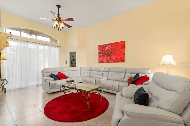 tiled living room with ceiling fan and a high ceiling