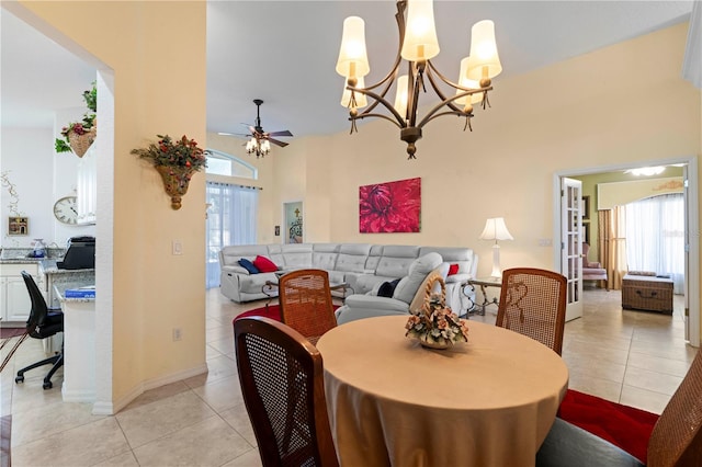 tiled dining room featuring ceiling fan with notable chandelier and a wealth of natural light