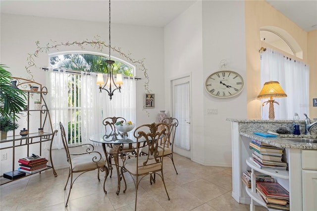 tiled dining space with sink and a notable chandelier