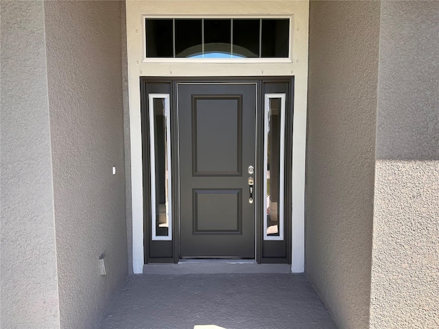 entrance to property featuring stucco siding