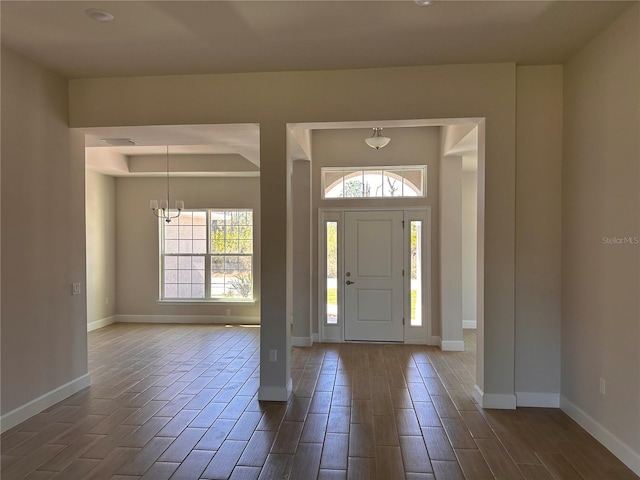 foyer entrance with wood finish floors, a healthy amount of sunlight, and baseboards