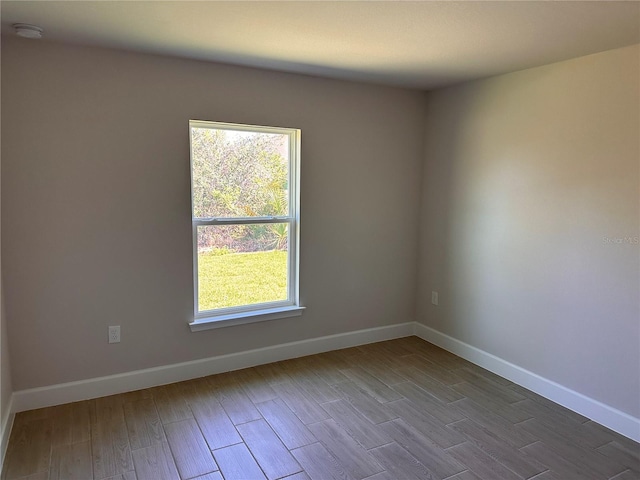 empty room featuring wood finished floors and baseboards