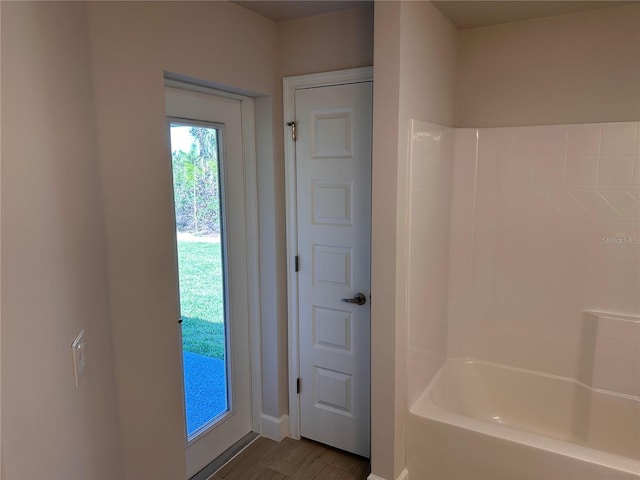 full bathroom with shower / washtub combination, a closet, wood finished floors, and baseboards