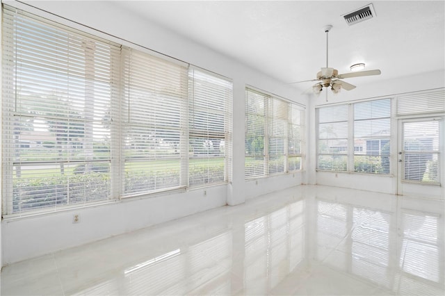 unfurnished sunroom with ceiling fan and a healthy amount of sunlight