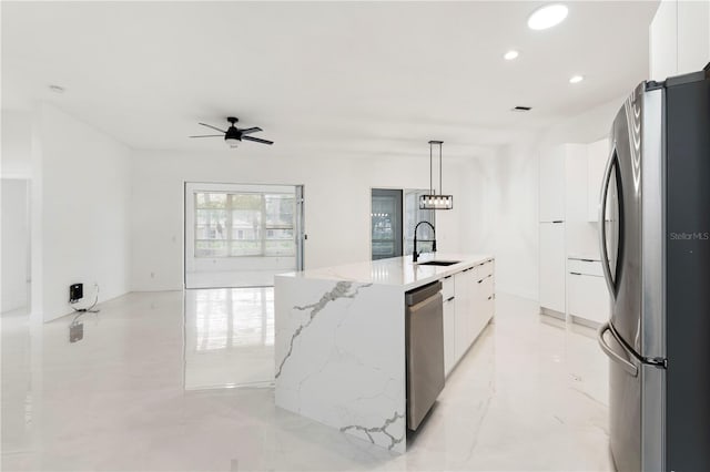 kitchen with an island with sink, appliances with stainless steel finishes, sink, and white cabinetry