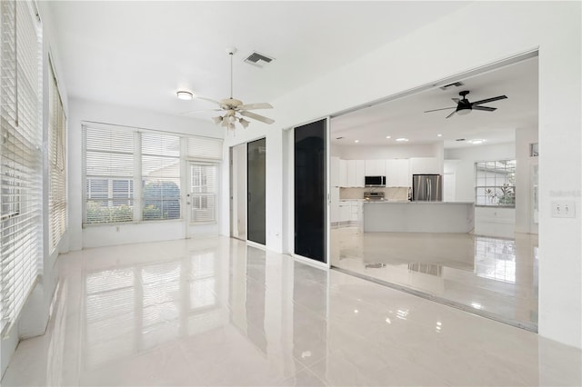 unfurnished room with ceiling fan and light tile patterned floors