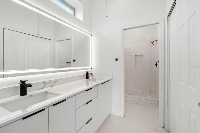 bathroom with tiled shower and vanity