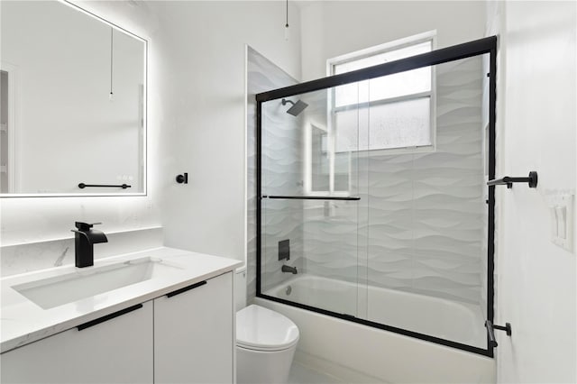 full bathroom featuring toilet, vanity, and combined bath / shower with glass door