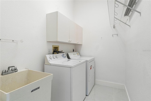 laundry area featuring washing machine and clothes dryer, sink, and cabinets