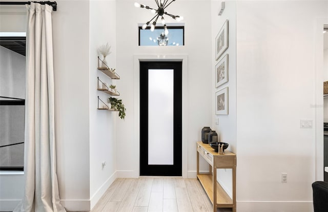 entrance foyer with light hardwood / wood-style flooring and a notable chandelier