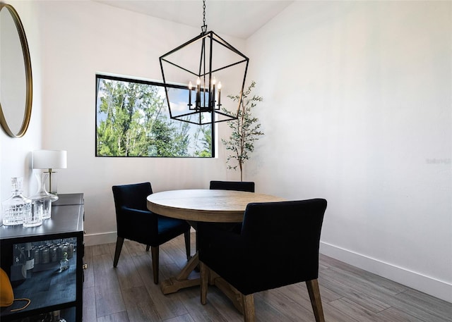 dining room featuring an inviting chandelier, lofted ceiling, and hardwood / wood-style floors