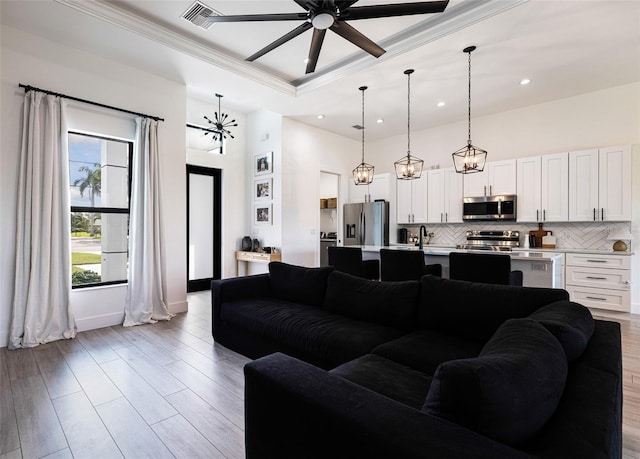 living room with ceiling fan, light hardwood / wood-style floors, and ornamental molding