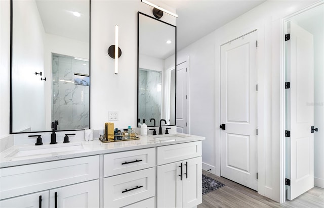 bathroom featuring wood-type flooring, a shower with door, and vanity