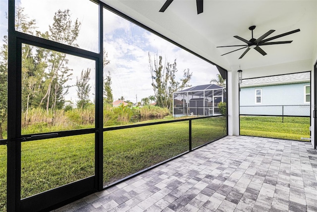 unfurnished sunroom featuring ceiling fan