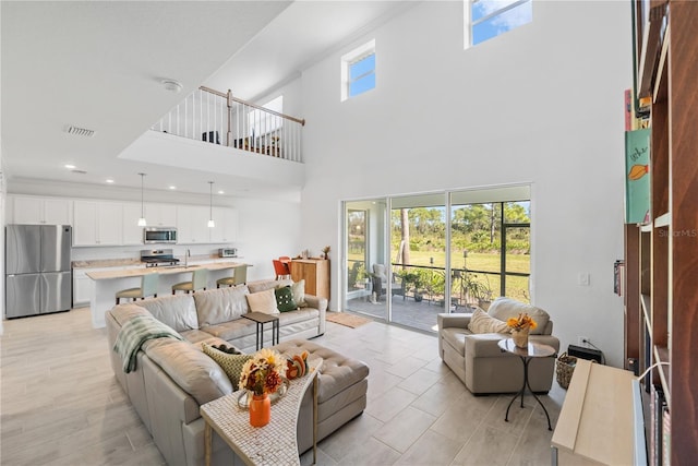 living room with a high ceiling and light wood-type flooring