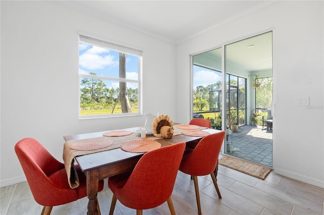 dining space featuring light tile patterned floors and crown molding