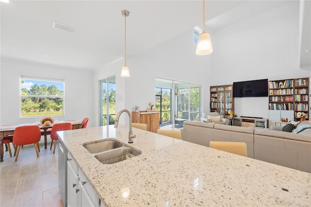 kitchen featuring a healthy amount of sunlight, white cabinetry, sink, and hanging light fixtures