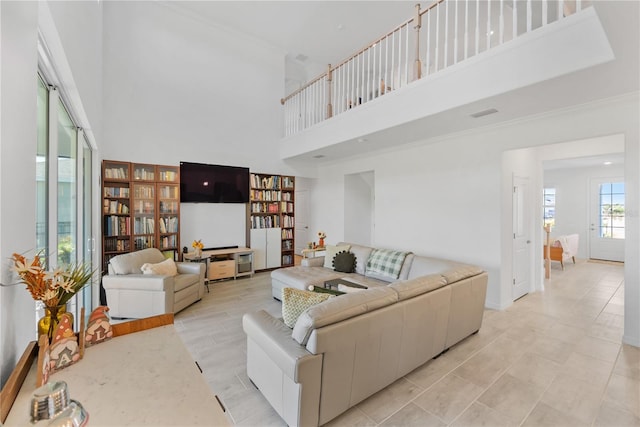 living room with a towering ceiling and light tile patterned flooring