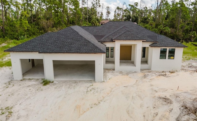 2502 Pinewood St, North Port, FL 34288 - view of front of property with a shingled roof and stucco siding