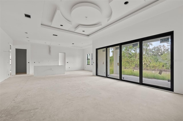 unfurnished living room with a raised ceiling and ceiling fan