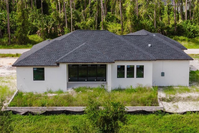 2502 Pinewood St, North Port, FL 34288 - rear view of house with stucco siding and roof with shingles