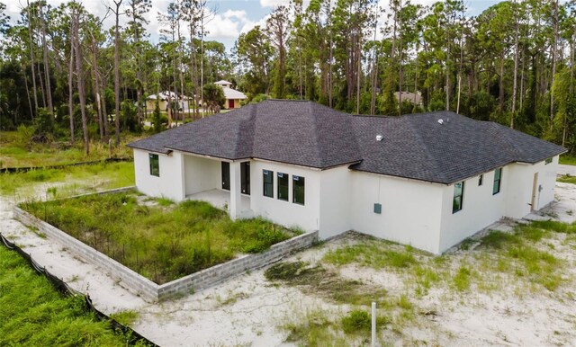 2502 Pinewood St, North Port, FL 34288 - rear view of property with stucco siding and roof with shingles