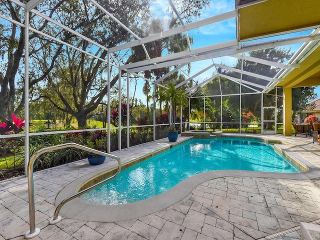 view of pool with glass enclosure and a patio area