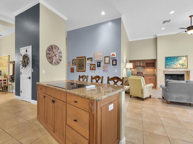 kitchen with light tile patterned floors, black electric cooktop, ornamental molding, and a high end fireplace