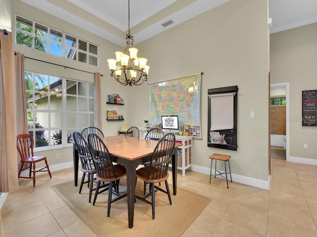 tiled dining space featuring an inviting chandelier, a towering ceiling, and ornamental molding