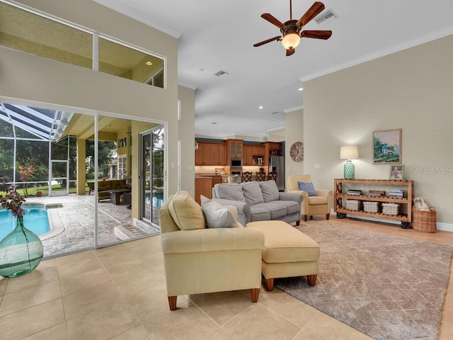 tiled living room featuring ornamental molding, a towering ceiling, and ceiling fan