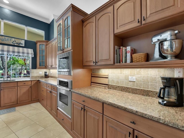 kitchen featuring decorative backsplash, stainless steel appliances, light stone counters, and light tile patterned floors