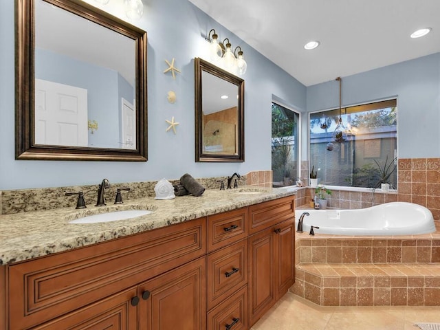 bathroom with a relaxing tiled tub, tile patterned floors, and vanity