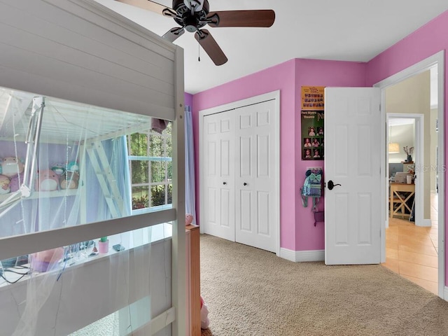 carpeted bedroom featuring ceiling fan and a closet