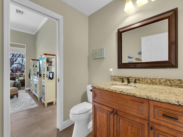 bathroom featuring tile patterned flooring, crown molding, vanity, and toilet