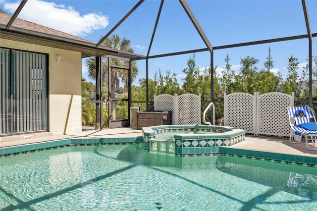 view of swimming pool featuring an in ground hot tub and a lanai