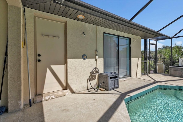 view of pool featuring glass enclosure and a patio area