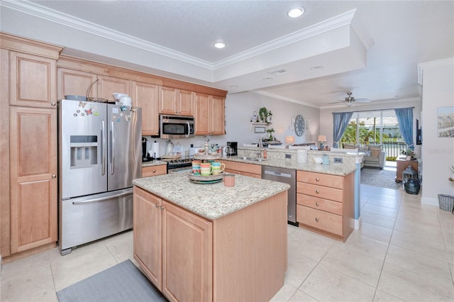 kitchen featuring stainless steel appliances, kitchen peninsula, ornamental molding, and a center island