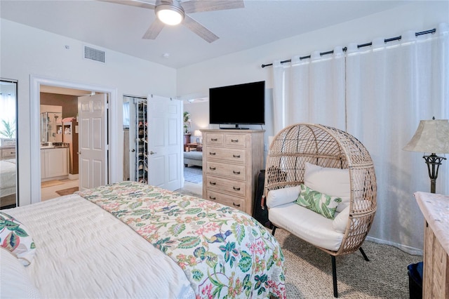 carpeted bedroom featuring ceiling fan and ensuite bath