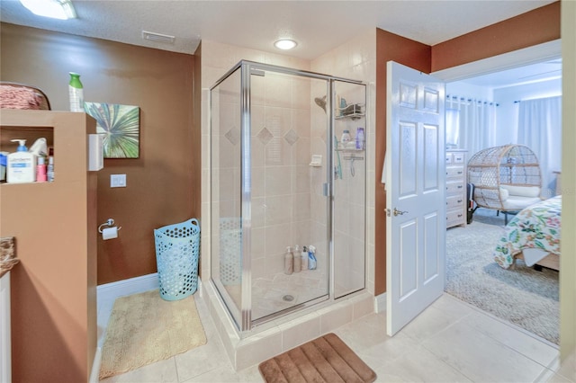 bathroom with a shower with door and tile patterned floors