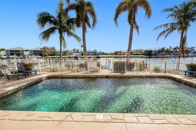 view of swimming pool featuring a water view and a patio