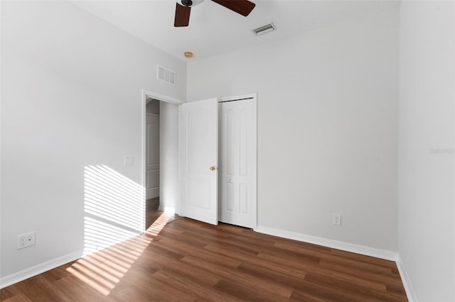 unfurnished bedroom featuring visible vents, dark wood finished floors, and baseboards