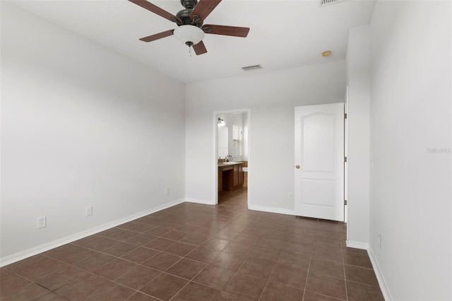 unfurnished bedroom with visible vents, ceiling fan, ensuite bath, dark tile patterned flooring, and baseboards