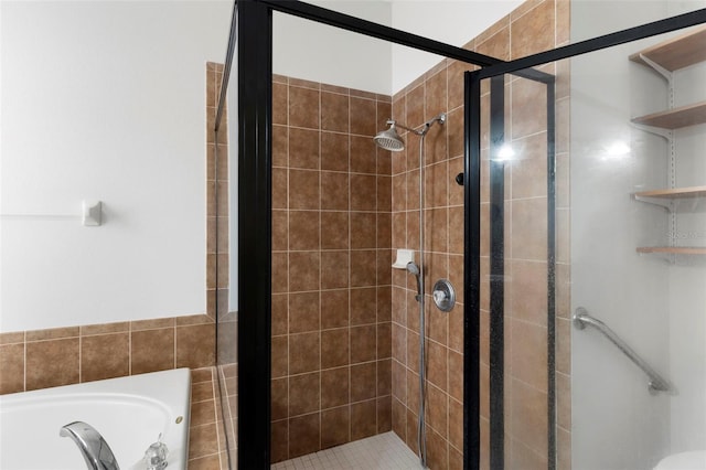 bathroom with a shower stall and a bath