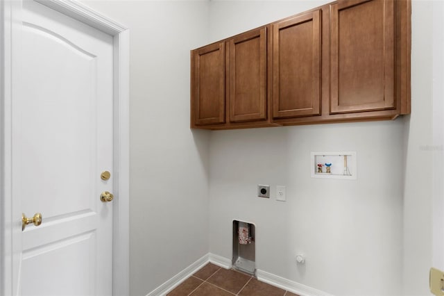 laundry area featuring hookup for an electric dryer, dark tile patterned floors, washer hookup, baseboards, and cabinet space