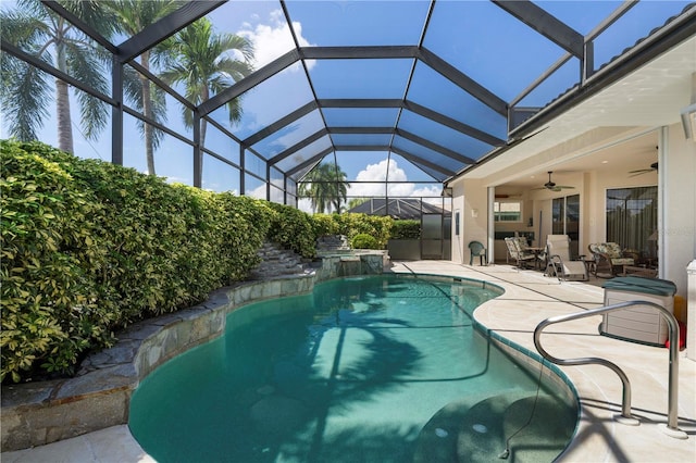 view of swimming pool with a patio, ceiling fan, and glass enclosure