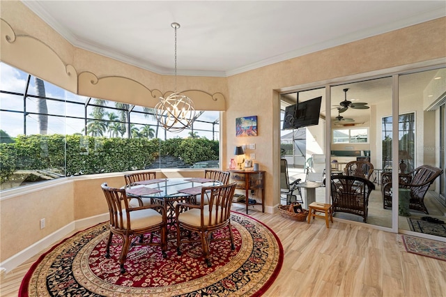 dining area featuring crown molding, hardwood / wood-style flooring, and ceiling fan with notable chandelier